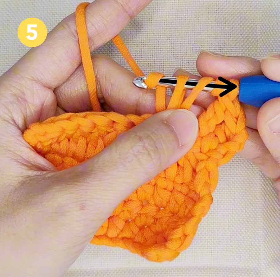 Garn durch zwei Schlaufen ziehen